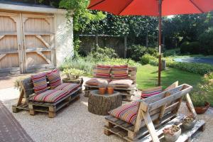 un patio con 2 sillas y una mesa con sombrilla en Authentieke privé-kamer bij Karen en Beveren