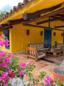 a patio with a couch and a table and flowers at Casa Benigno muy cerca de Ginebra in Ginebra