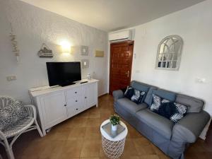 ein Wohnzimmer mit einem Sofa und einem Flachbild-TV in der Unterkunft Apartamento Urb Oasis Park II Denia, las Marinas in Denia