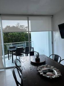 una mesa de comedor y sillas con vistas a un balcón en Precioso Loft a pie de playa, en Nuevo Vallarta 