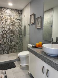 Un baño con lavabo, inodoro y ducha. en Precioso Loft a pie de playa, en Nuevo Vallarta 