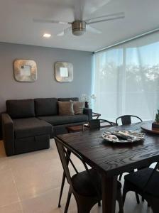 una sala de estar con una mesa y un sofá en Precioso Loft a pie de playa, en Nuevo Vallarta 