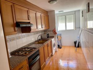 cocina con armarios de madera y horno con fogones en Edificio La Horteta, en La Font D´En Carròs