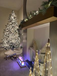 a living room with a christmas tree and christmas lights at Devonshire Bungalow - close to the Coast & Lakes. in Cleator