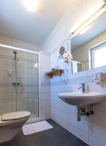 a bathroom with a sink and a shower and a toilet at Hotel Bau Maribor in Maribor