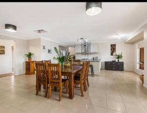 comedor y cocina con mesa y sillas en Modern family home with pool, en Carisbrook
