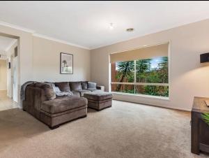 sala de estar con sofá y ventana grande en Modern family home with pool, en Carisbrook