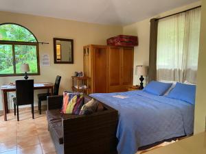 a bedroom with a bed and a desk and a chair at The Casita at The Boquete Hacienda in Boquete