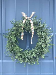 a wreath on a blue door with a bow at Adorable 2 Bedroom Cottage with spacious veranda in Hermanus