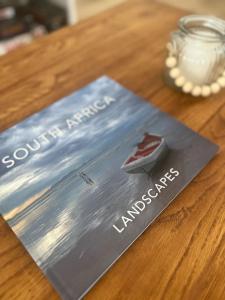 a book sitting on top of a wooden table at Adorable 2 Bedroom Cottage with spacious veranda in Hermanus +29 photos