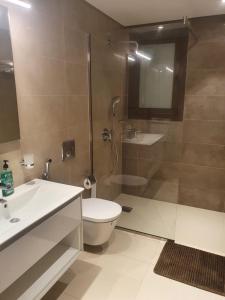 a bathroom with a shower and a toilet and a sink at Forest Island apartment in Salalah in Salalah