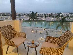 two chairs and a table on a balcony with a view at Forest Island apartment in Salalah in Salalah
