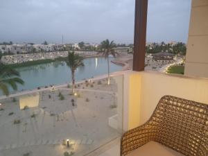 a balcony with a view of a beach and palm trees at Forest Island apartment in Salalah in Salalah +6 photos