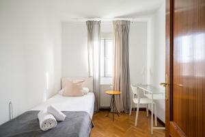 1 dormitorio con cama, escritorio y ventana en MODERN AND BRIGHT APARTMENT Plaza Elíptica -MAGIN, en Madrid