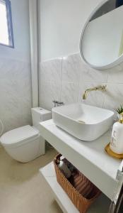 een witte badkamer met een wastafel en een toilet bij Helena’s Studio Suite Gerik in Gerik