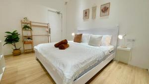 a bedroom with a white bed with a teddy bear on it at Helena’s Studio Suite Gerik in Gerik
