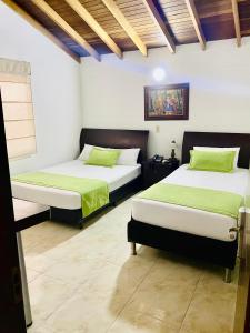 1 dormitorio con 2 camas con sábanas verdes en Hotel Palma 70 en Medellín