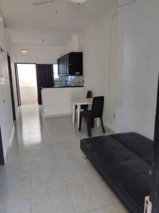 Zimmer mit einem Bett und einem Tisch sowie einer Küche in der Unterkunft Apartamento Arboletes a 2 cuadras playa principal in Arboletes