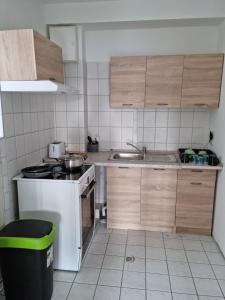 a kitchen with wooden cabinets and a white stove at City Centre Unterkunft in Itzehoe