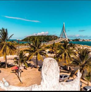a view of a beach with palm trees and a bridge at kitnet pé na areia reservado por sayonara in Ilhéus