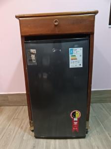 a small black refrigerator with a wooden top at kitnet pé na areia reservado por sayonara in Ilhéus