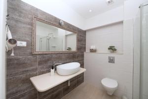 a bathroom with a sink and a toilet and a mirror at Apartments Talija in Drasnice +43 photos