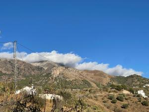 a view of a mountain with clouds in the sky at Casa del Limon in Canillas de Aceituno