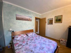 a bedroom with a bed with a floral bedspread at SARA'S in Bardonecchia