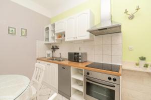 a kitchen with white cabinets and a stove top oven at Apartments Talija in Drasnice