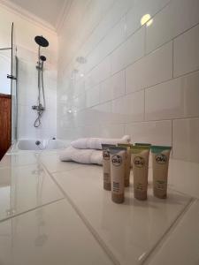 a bathroom with three cups on a white tiled floor at Estancia Río Penitente in Villa Tehuelche 