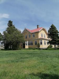 a large yellow house with a large grass field at Estancia Río Penitente in Villa Tehuelche 