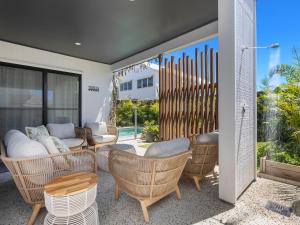 a patio with wicker chairs and tables on a patio at Sea Spray by Kingscliff Accommodation in Kingscliff