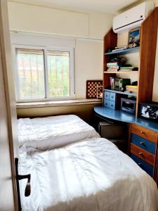 a bedroom with a bed and a desk and two windows at Bella Vista House in Chiva