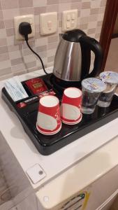 هوتيل حايل للشقق المفروشة يتوفر شهري سنوي في حائل: وعاء الشاي والأكواب على صينية على موقد