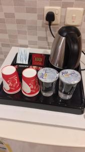 a tray with cups and a tea pot on a stove at هوتيل حايل للشقق المفروشة يتوفر شهري سنوي in Hail