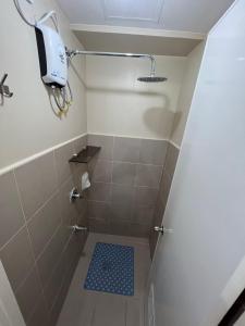 y baño con ducha y alfombra de ducha azul. en Cozy 2 Bedroom Condo with Balcony for Rent, en Iloilo City
