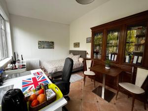een woonkamer met een keuken en een woonkamer met een tafel bij Charming independent guest house - Grand studio avec terrasse et jardin in Saint-Maur-des-Fossés