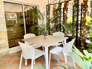 una mesa y sillas en un patio con plantas en Hotel Palma 70, en Medellín