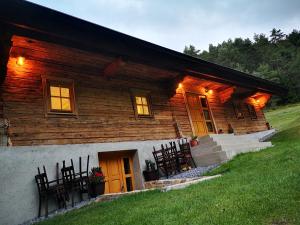 a log cabin with a group of chairs in front of it at Valle Divina in Mislinja