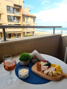 una mesa con una bandeja de comida y una copa de vino en Urlaub - Obzor Beach Resort A109, en Obzor