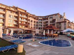 un hotel con piscina, mesas y sombrillas en Urlaub - Obzor Beach Resort A109, en Obzor