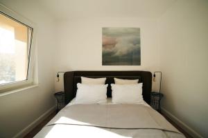Una cama con sábanas blancas y almohadas en un dormitorio en Ultracentral two rooms apartment in Bucharest, en Bucarest