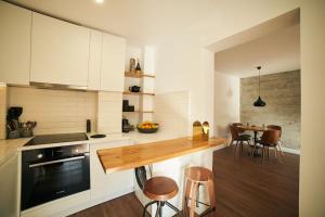 una cocina con armarios blancos y una mesa con sillas. en Ultracentral two rooms apartment in Bucharest, en Bucarest