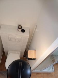 uma pequena casa de banho com um WC e uma cadeira em LE CLOS DE BEAUCHAMP APPARTEMENT Le BORD DE MER 2 vélos sont disponibles gratuitement em Saint-Valery-sur-Somme