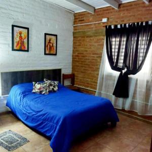 um quarto com uma cama azul e uma janela em Cabaña Sarita em Santa Rosa