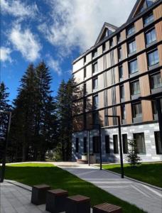 a large building with a lawn in front of it at Woodside Duplex Apartment Ski in Ski out with garage in Kopaonik