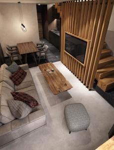 a living room with a couch and a table at Woodside Duplex Apartment Ski in Ski out with garage in Kopaonik