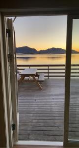 a view from the door of a deck with a picnic table at Rorbu i Lofoten in Leknes