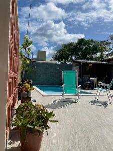 a patio with two chairs and a swimming pool at Pousada Casa Mariscal in Bombinhas