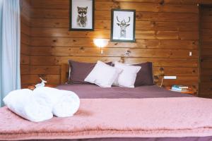 a bedroom with a bed with a wooden wall at Comfortable Cosy Retreat in Rotorua